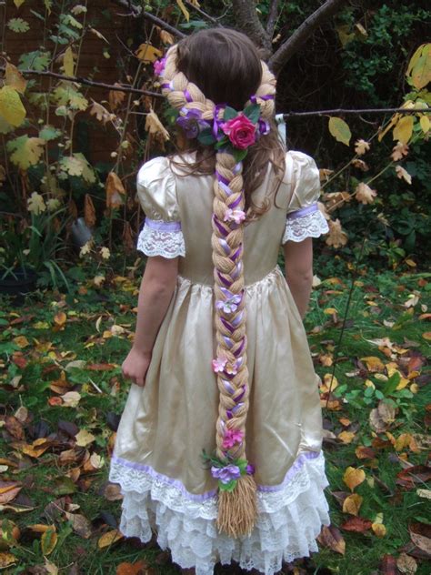 Braid intertwined with ribbon and ribbon rosettesflower with glitter edges and jewel centre in backribbon bow on bottomside combs for a secure fitbraid 30'' lone. Rapunzel Braid head piece with flowers custom made ...