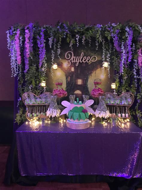 A Purple Table Topped With Cake And Flowers