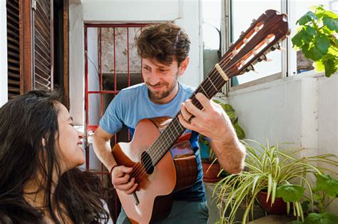 Young Latin Caucasian Man At Home Serenades His Pregnant Wife With His