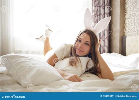 Lovely Brunette Girl With Bunny Ears On Her Head And Lying With Coffee