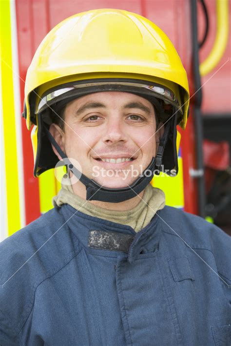 Portrait Of A Firefighter Standing In Front Of A Fire Engine Royalty