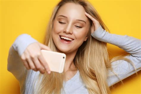 Premium Photo Selfie Time Young Smiling Blond Woman Doing Selfie On Yellow Background