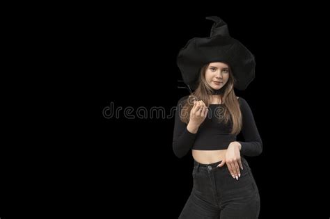 teenage girl in form of witch wears black clothes pointed hat and holds glasses isolation on