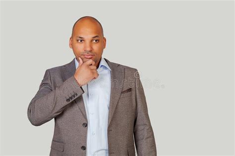 A Smart Confident African American Young Man In A Suit Holds His Chin