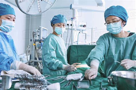 Surgeons Performing Surgery On Patient Abdomen In Maternity Ward