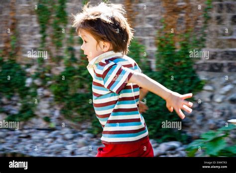 Caucasian Child Boy 4 5 Year Old Running In Garden Backlit By