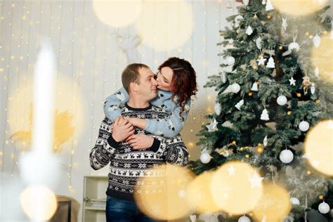 Young Couple In Love In Christmas Decor With Ts And Christmas Tree