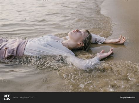 Beautiful Young Girl Is Lying Sand In The Sea And Closing Her Eyes In