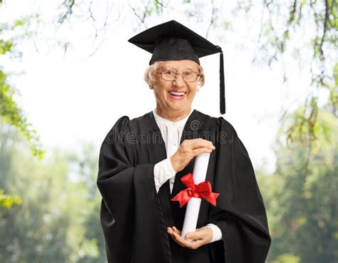 Senior Female Graduate In A Graduation Gown With A Diploma Posing