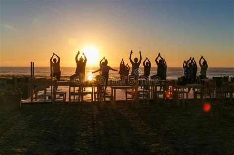 Group Doing Yoga Exercises On The Beach At Sunset Editorial Photography
