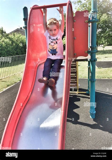 Young Boy Playing On A Slide In A Playground Stock Photo Alamy
