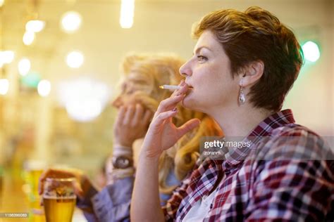 Mid Adult Woman Smoking Cigarettes In Bar High Res Stock Photo Getty