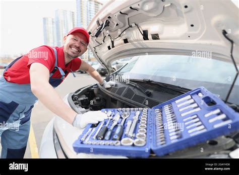 Smiling Repairman In Uniform Fixing Car With Tools Stock Photo Alamy