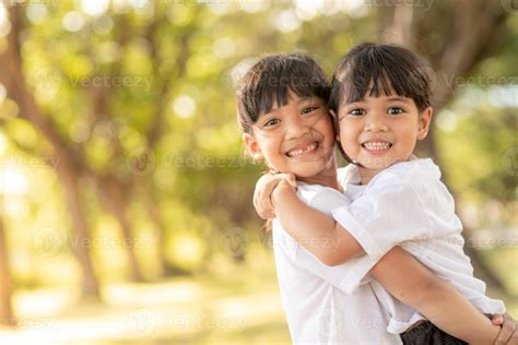 Two Asian Little Child Girls Hugging Each Other With Love In The Garden