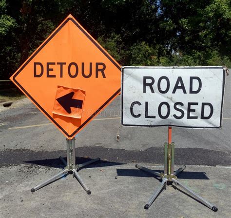 Road Closed And Detour Signs Flanked With Orange Safety Cones Stock