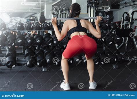 Beautiful Sporty Woman Doing Squats With Barbell At Gym Stock Photo