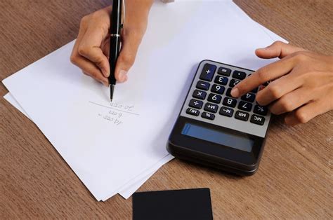 Free Photo Closeup Of Person Calculating On Calculator And Writing