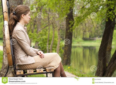 Schöne Junge Frau Die Auf Bank Im Park Nach Vorn Schaut Sitzt
