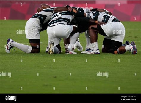 Fiji Players Kneel Together As They React After Winning Gold Over New Zealand In Mens Rugby