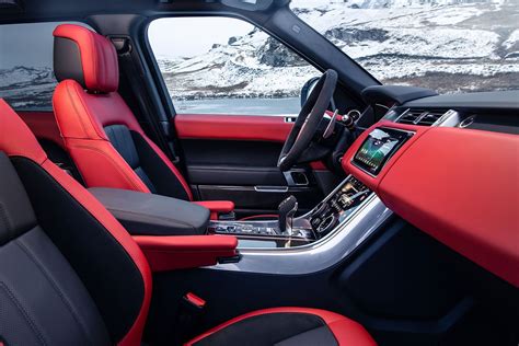 The Interior Of A Vehicle With Red And Black Seats
