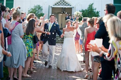A Bride And Groom Walk Down The Aisle As Confetti Is Thrown Around Them
