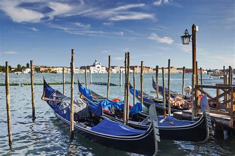 Blue Gondolas In Venice And View Of The Sea And The Palace At Sunset
