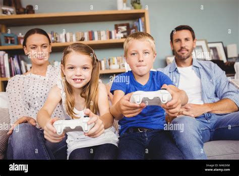 Smiling Siblings Playing Video Games With Parents Stock Photo Alamy