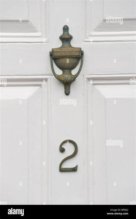 Number 2 wooden white painted paneled front door with brass knocker