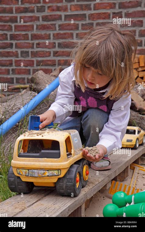 Little Girl Playing With A Toy Car In A Sandpit Stock Photo Alamy