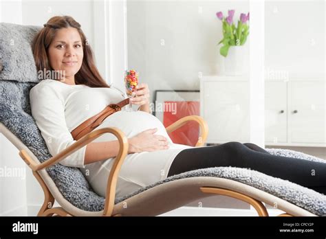Pregnant woman lying in lounge chair Stock Photo - Alamy