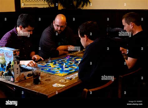 People Playing A Board Game In A Traditional Pub England Uk Stock Photo