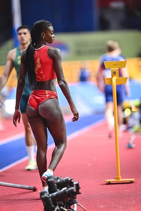 a woman in red and black running on a track