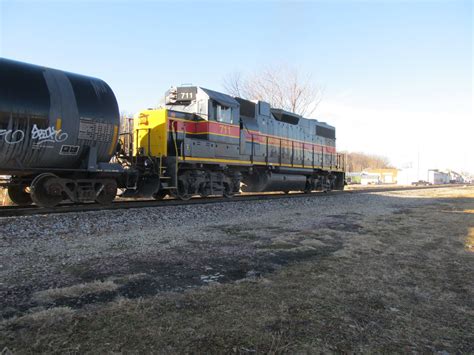 a train is traveling down the tracks with graffiti painted on it's side,