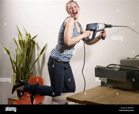 A Woman Drilling Into A Wall Stock Photo Alamy