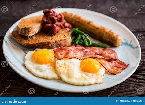 Typial Breakfast With Eggs Bacon And Sausage On Plate Stock Image