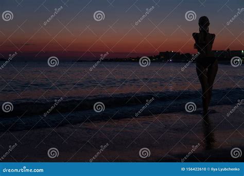 sexy girl steht am strand bei sonnenuntergang im meer mit einer silhouette stockfoto bild von