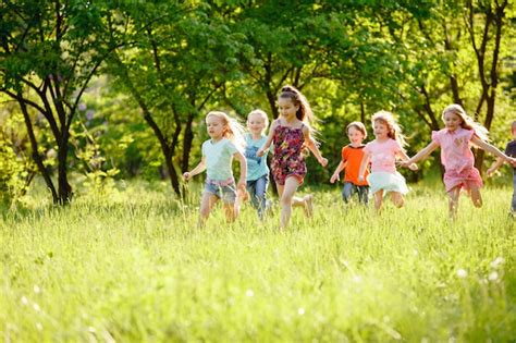Un Grupo De Niños Que Juegan Y Que Corren En El Parque En Un Gozon