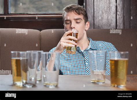 Young Man Drinking Beer In Bar Stock Photo Alamy