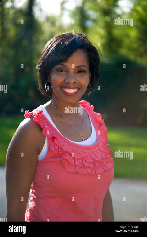 Affluent African American Woman In Her S Smiles Next To Home