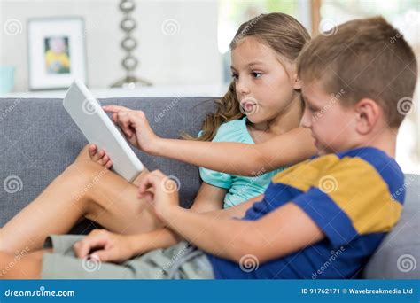 Siblings Using Digital Tablet In Living Room Stock Image Image Of Clothing Leisure 91762171