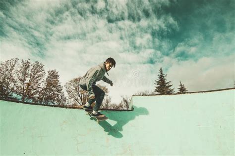 Guy Skateboarder Riding A Skateboard On A Skatepark Young Man Jumping