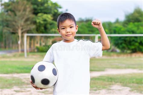 Happy Asian Child Boy Playing And Holding A Football Toy In His Hands