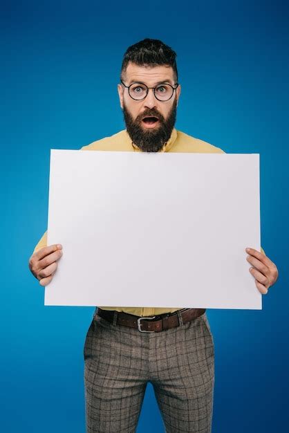 Premium Photo Shocked Man Holding Blank Placard Isolated On Blue