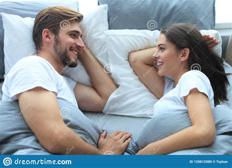 Cheerful Couple Awaking And Looking At Each Other In Bed Stock Image