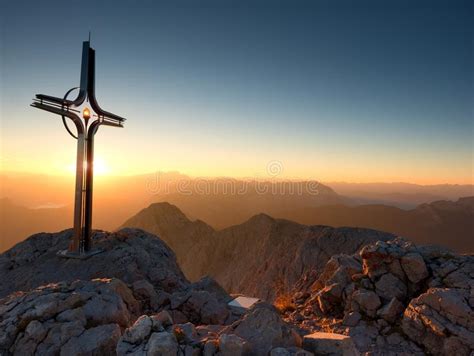 Cross Raised At Mountain Summit In Alps Sharp Peak Daybreak Sun Stock
