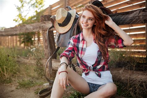 Happy Smiling Young Redhead Cowgirl Resting At The Ranch Fence Royalty Free Stock Image