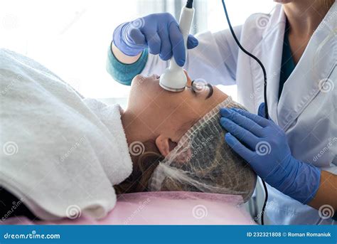 Cosmetologist Doing Phonophoresis Procedure For Young Lady Who Lying At