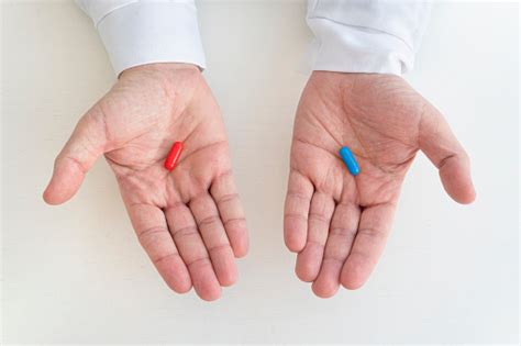 A Red And Blue Pill In A Mans Hand The Concept Of Choosing Treatment