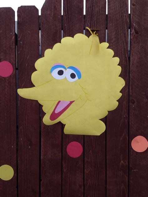 A Paper Cut Out Of A Sesame Character Hanging On A Wooden Fence With