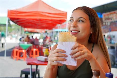 Premium Photo Cute Brazilian Girl Eating Pastel De Feira Stuffed